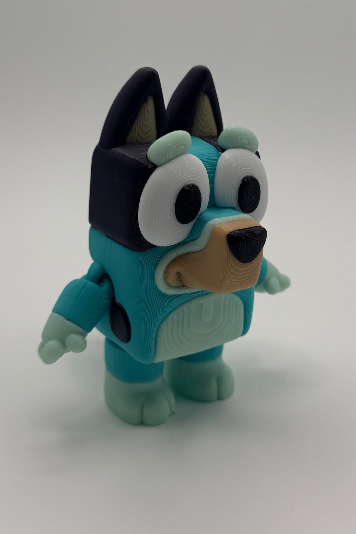 Toy figure of a character with blue body and black and white face on a white background